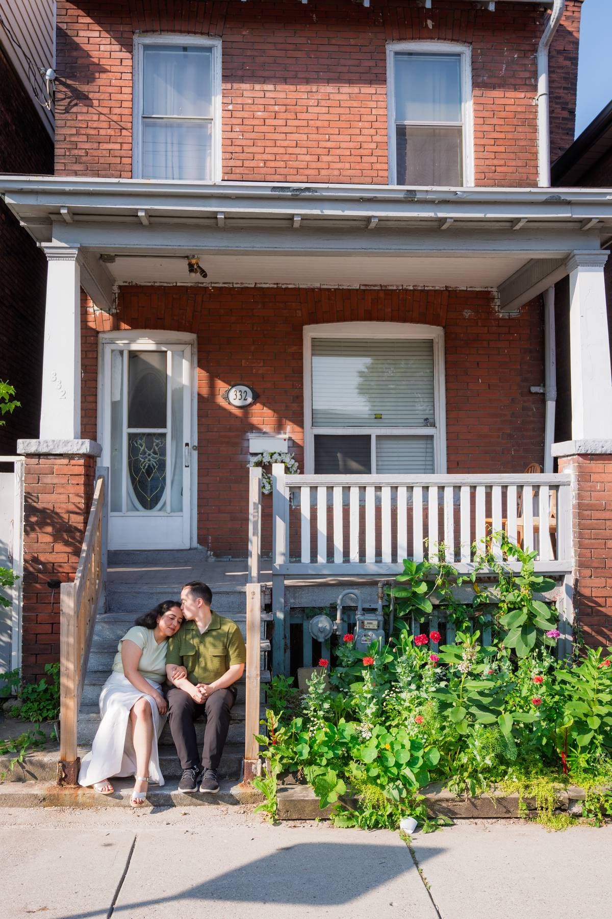 Sanjika and Andy sitting close together on a porch step